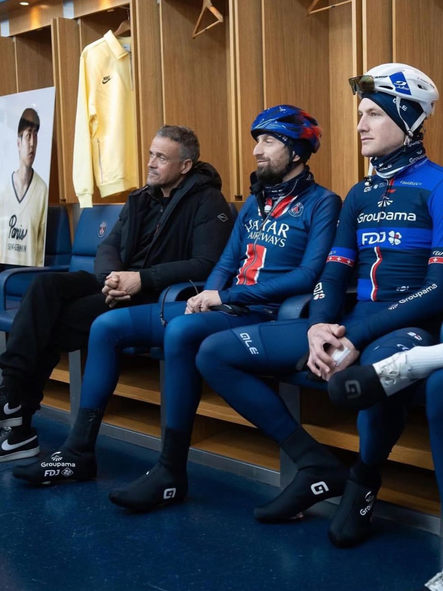 Cyclistes en tenue d'équipe, casque sur la tête, assis dans un vestiaire
